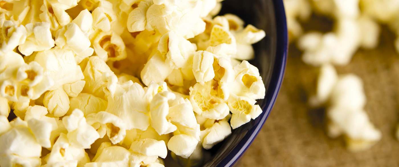 Close up shot of sweet popcorn in a blue bowl.
